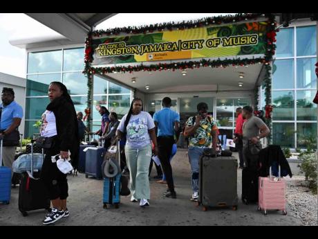 Credit: Ricardo Makyn/Chief Photo Editor Travellers arriving in Jamaica at the Norman Manley International Airport in Kingston on Monday, three days before Christmas Day.