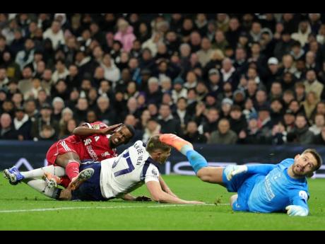 Liverpool’s Alexander Isak (left) grimaces as he picks up an injury in a challenge from Tottenham’s Micky van de Ven as he scores the opening goal during the English Premier League  match between Tottenham and Liverpool in London, Saturday, December 20