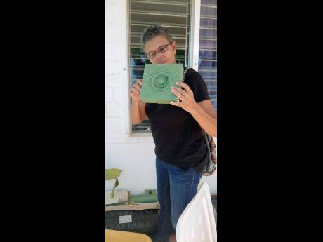Credit: Paul Williams Allison Morris inspecting an object that was among the debris of the St John’s Anglican Church in Black River, St Elizabeth.
