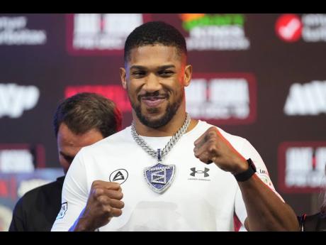 Anthony Joshua stands on stage during a face-off against Jake Paul at a news conference promoting their heavyweight boxing match on Wednesday, December 17 in Miami Beach, Florida.