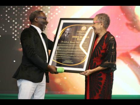 Fae Ellington (right) presents a citation to Owen ‘Blakka’ Ellis, in recognition of his contribution to comedy.