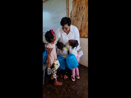 Credit: Contributed Above: Smith interacting with children who participated in the Bahali Hurricane Recovery Project in St Elizabeth.
