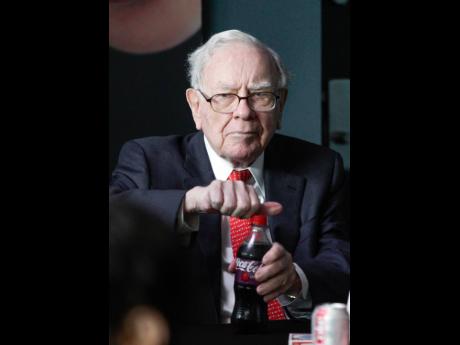 Warren Buffett, outgoing CEO of Berkshire Hathaway, opens a bottle of Cherry Coke during a game of bridge outside Berkshire-owned Borsheims jewellery store in Omaha, Nebraska, USA. 