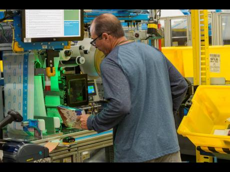 AP Photos
An employee uses an automated packaging machine to create a made-to-measure bag for a book at Amazon OXR1 fulfilment centre in Oxnard, California, USA in 2024. 