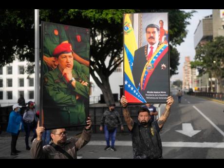 Government supporters display posters of Venezuelan President Nicolás Maduro, right, and former President Hugo Chávez in downtown Caracas, Venezuela, Saturday, January 3, 2026, after US President Donald Trump announced that Maduro had been captured and f