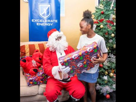Credit: Contributed Oneika Broomfield of Old Harbour Bay is thrilled to receive a gift from Santa during the toy donations held at the Old Harbour Bay Community Centre.