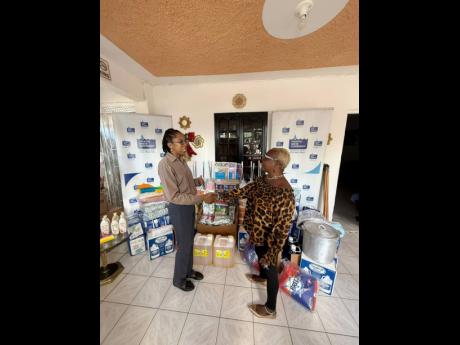 Credit: Contributed Acting Community Relations Manager (eastern), Ann Bolt (left), hands over donated items to Sandy Frazer-Jackson, manager of the Ultimate Care Home, during a presentation at the facility in Catherine Hall, St James.