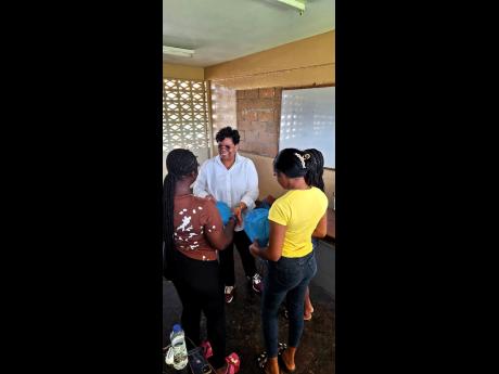 Dr Marsha Smith, with a few of the young adults following the Bahali Hurricane Melissa Recovery Project hosted by the Newell High School in St Elizabeth.