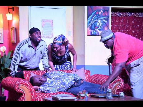 Glen Campbell, who plays Boopsie, faints after his wife Petal, played by Renae Williams (centre), explains to him that she lost the funds that he sent to her to build a house to a failed investment scheme. Her brother, Larry, played by Courtney Wilson (lef