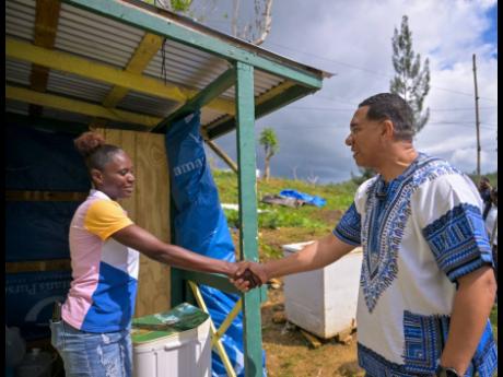 Prime Minister, Dr Andrew Holness, greets resident of Accompong, St Elizabeth, Coleen Hutchinson, during a tour of homes in the area on Tuesday, January 6, 2026. Hutchinson is among residents who have benefited from roof repair works being conducted in the