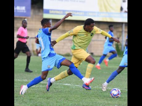 Treasure Beach FC’s Karim Bryan (right) evades a tackle from Molynes United’s Rashawn Livingston during their Jamaica Premier League football match at Drewsland yesterday. Treasure Beach FC’s Karim Bryan (right) evades a tackle from Molynes United’