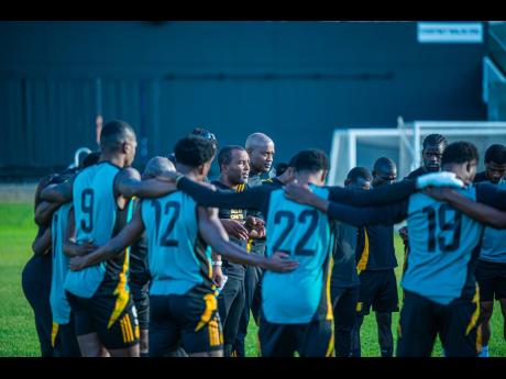 
Reggae Boyz interim coach, Rudolph Speid, gets into a huddle with his charges during a training session at Sabina Park.