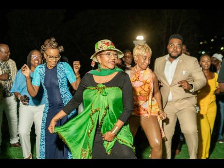Dr Marcia Griffiths (front centre) shares a light-hearted moment with specially invited guests as they break into her global hit, the Electric Boogie, during the post-graduation reception at her residence on Saturday.