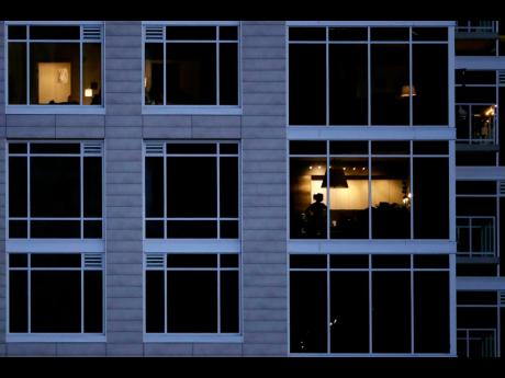 Credit: AP A person looks out of a window in an apartment building in Kansas City, Missouri.