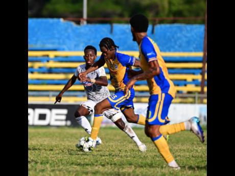 Harbour View’s Dontaye Omar-David Mullings (centre) dribbles away from Cavalier’s Dwayne Allen during a Jamaica Premier League football match at the Harbour View Mini-Stadium in December of 2025. Looking on is Harbour View’s Rohan Brown.