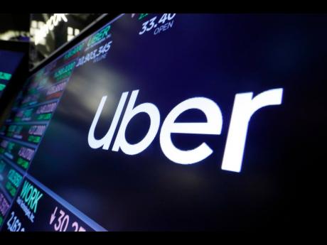 The Uber logo appears above a trading post on the floor of the New York Stock Exchange, August 16, 2019. (AP Photo/Richard Drew, File)