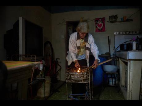 Credit: AP Minorkys Hoyos Ruiz lights coals to cook dinner during a scheduled blackout to ration energy in Santa Cruz del Norte, home to one of Cuba’s largest thermoelectric plants, late afternoon Tuesday, Feb. 3, 2026.