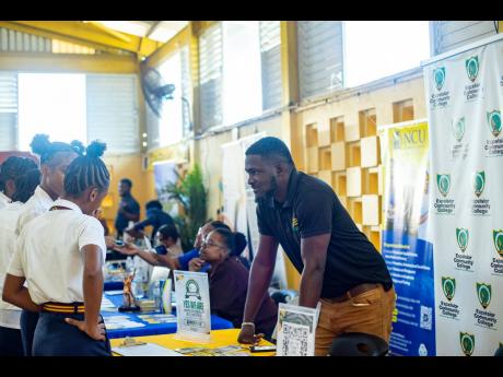 An exhibitor answers students’ questions at the Kiwanis Club of Linstead College Fair.

