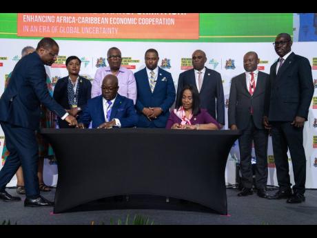 Mrs Kanayo Awani, executive vice-president, intra-African trade & export development, Afreximbank, and  Dominic Sturrup, executive chairman,  Bahamas Striping Group of Companies Ltd (BSGC), during the signing of the financing agreement. Standing (from left