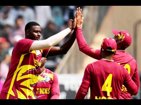 West Indies’ Jason Holder (left) celebrates with teammates after taking the wicket of Nepal’s Aarif Sheikh (not in photo) during the T20 World Cup cricket match in Mumbai, India, on Sunday.