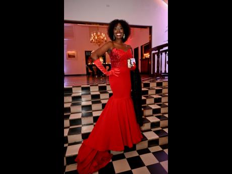 Raising the bar in a red gown is Nadine Spence, managing director of Sixt Rent A Car, who wears a locally designed gown by BrandEd at the annual Sugar Cane Ball.
