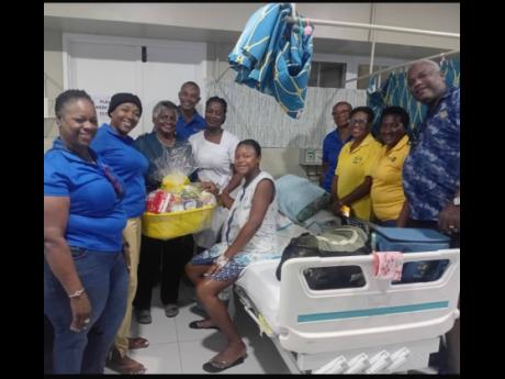 Members of the Rotary Club of Savanna-la-Mar present a hearty gift basket to Nicole Taylor, mother of the first baby girl of the year, Aneila Heaven.