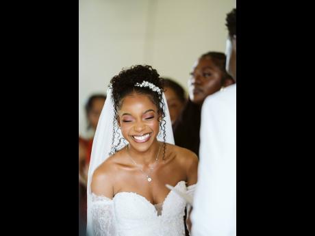 Mrs Thomas is captured in a candid moment, wearing a Frederique ivory beaded mermaid gown from Bliss Bridal Boutique.