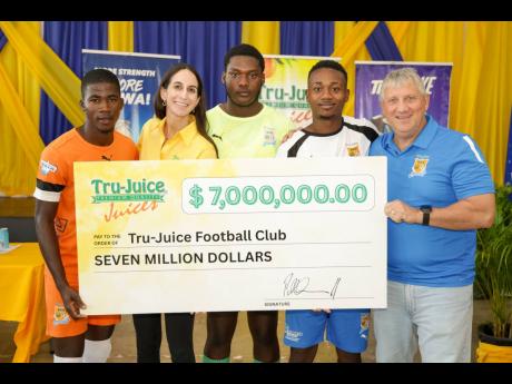 Lauren Mahfood (second left), marketing manager at Trade Winds Citrus Limited, and Peter McConnell (right), managing director of Trade Winds Citrus Limited, share a moment with members of the Tru-Juice Football Club following the formal handover of a $7-mi