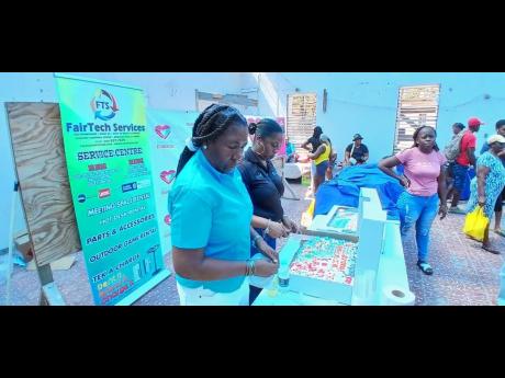 Credit: Contributed Janet Richards (left), founder of the Janet Richards Foundation, and Nathalie Fairweather, manager of Fairtech Services Limited in Montego Bay, St James, prepare to serve refreshments to residents of Chatham, St James.