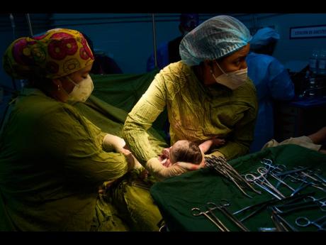 Doctors assist in a birth at the Ramón González Coro Maternity Hospital in Havana, Cuba, Friday, Feb. 20, 2026. 