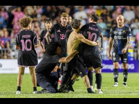 A fan (centre) got onto the field and grabbed Inter Miami’s Lionel Messi during an international friendly  match against Ecuador’s Independiente del Valle in Bayamon, Puerto Rico, on Thursday night.
