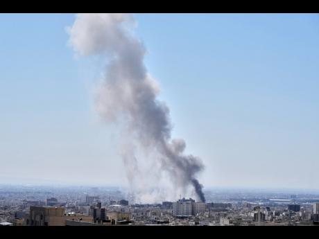 A plume of smoke rises after a strike in Tehran, Iran in March 1, 2026. (AP Photo/Vahid Salemi)