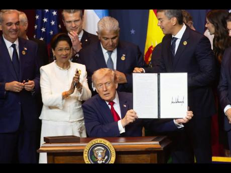 United States President Donald Trump is joined by Trinidad and Tobago Prime Minister Kamla Persad-Bissessar at the signing ceremony for the agreementt establishing the military alliance known as the Americas Counter-Cartel Coalition.