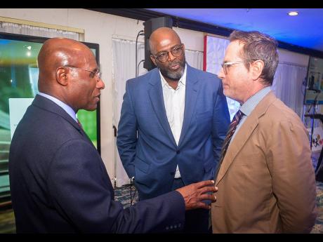 Minister of Industry, Investment and Commerce, Senator Aubyn Hill (left), engages in discussion with Acting Chief Executive Officer of the Jamaica Business Development Corporation (JBDC), Harold Davis (centre), and Deputy Head of Cooperation at the Europea