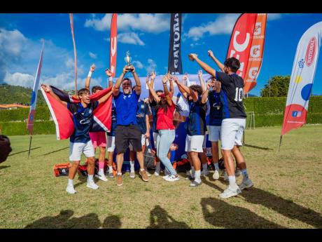Players and coaches from the International School of Port of Spain celebrate their boys’ championship victory at Soccer Feva 2026 at the American International School of Kingston.