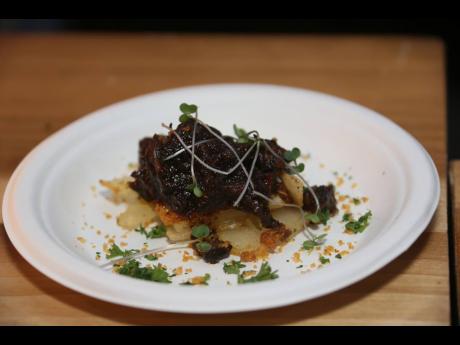 Chef Scotley Innis’ oxtail pavé, a slow-braised oxtail, layered with cassava and finished with potato foam and smoked parmesan for a refined take on the Jamaican classic.