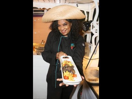 Chef Jacqui Tyson shows off her yard fire lamb, accompanied by charred corn and breadfruit succotash with roasted chickpeas.