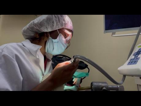 Jade Cohall-Cunningham demonstrates cavity preparation and restoration on a dental mannequin during her clinical practice.