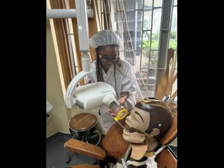 Focused on precision, Cohall-Cunningham takes dental X-Rays on a mannequin as part of her hands-on training.