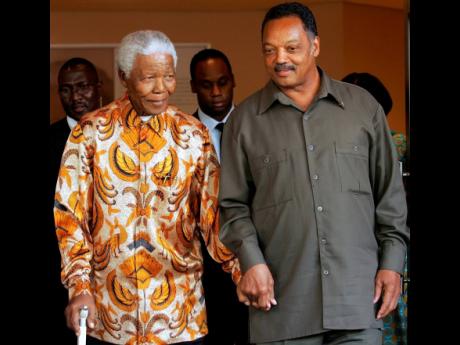 Nelson Mandela, left, walks with the Rev. Jesse Jackson after their meeting in Johannesburg, South Africa, in October 2005.