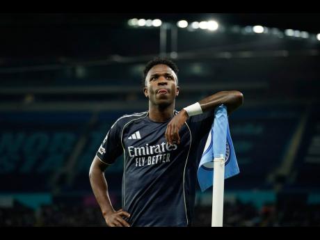 Real Madrid’s scorer Vinicius Junior reacts at the corner flag after scoring the opening goal from the penalty spot during the Champions League round-of-16 second-leg football match against Manchester City in Manchester, yesterday.
