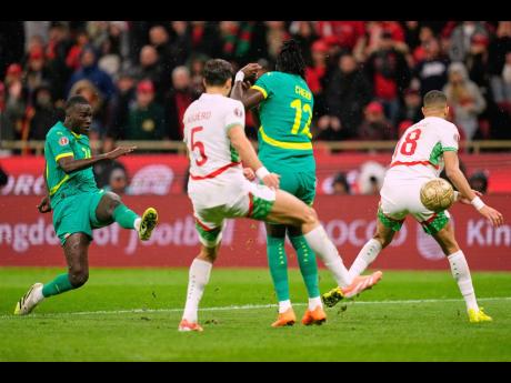 Senegal’s Pape Gueye (left) scores the opening goal during the Africa Cup of Nations final football match against Morocco, in Rabat, Morocco on January 18.