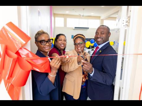 State Minister in the Ministry of National Security and Peace, Juliet Cuthbert-Flynn (left), joins in the cutting of ribbon to open a sewing lab at the South Camp Juvenile Correctional and Remand Centre in Kingston. Others (from left) are CEO, Digicel Foun