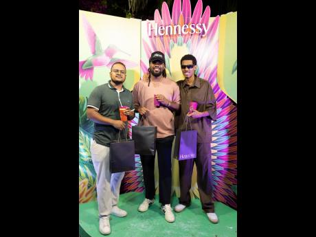 Credit: Contributed From left: Keanu Laing, business analyst, JMMB Group; Event Director Shaquille Blake; and musician Zac Jone$ show off their Hennessy carnival goody bags, filled with essentials.