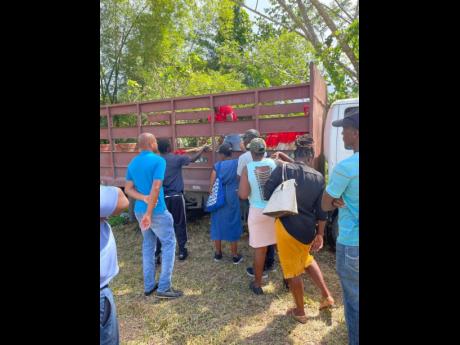 Farmers wait in line to collect supplies at the ‘Farmers’ Pop-Up’ initiative organised by Christopher Brown, member of parliament for St Mary South Eastern, on Wednesday.