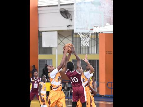 Credit: Antoine Lodge Andra Morgan (left) of Manchester High School moves to block a shot by Antonio Kerr of Herbert Morrison during their ISSA Rural basketball Under-16 finals at GC Foster College yesterday.