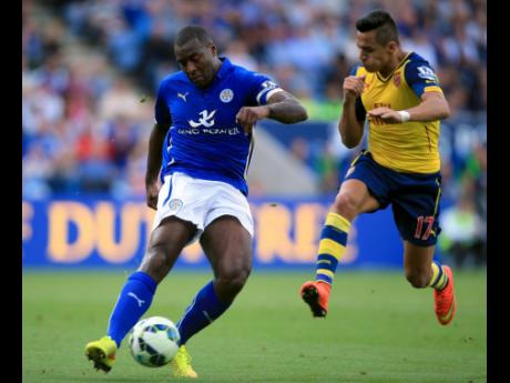 Credit: File Leicester City’s Wes Morgan plays a pass as he comes under pressure from Arsenal’s Alexis Sanchez (right), during their English Premier League football match at the King Power Stadium, Leicester, England, Sunday, August 31, 2014.