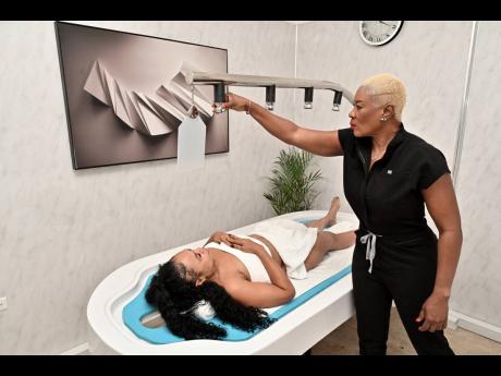 Credit: Rudolph Brown Andrea Johnson (right), makes preparations for a massage as model, Nicole Bolt, looks on.