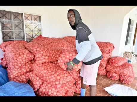 
Kevin Cooper, onion farmer in Heartease, St Thomas, with tons of onions stored on his aunt’s veranda.  
