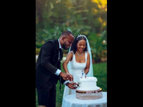 Mr and Mrs Thomas share a sweet moment cutting their cake, courtesy of Lola’s Dessert.